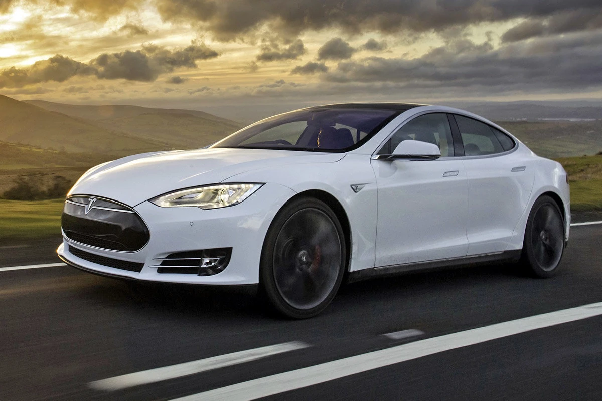 Tesla Model S на дороге среди холмов